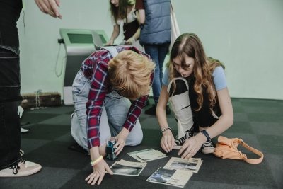 Dwójka nastolatków ogląda zdjęcia na podłodze