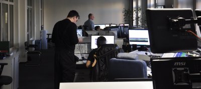 Centrum monitoringu w Gdyni. Widoczne biurka, monitory, kilku mężczyzn pracujących przy komputerach
