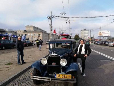 Nauczyciel na tle zabytkowego samochodu.