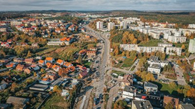 widok na ul. Wielkopolską, widok z góry, widoczna ulica, pojazdy, budynki oraz zieleń