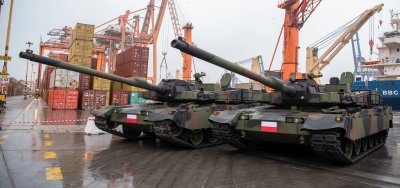 Terminal BCT w Gdyni, stoją dwa czołgi na betonowym placu, w tle pomarańczowe suwnice i sprzęt terminala