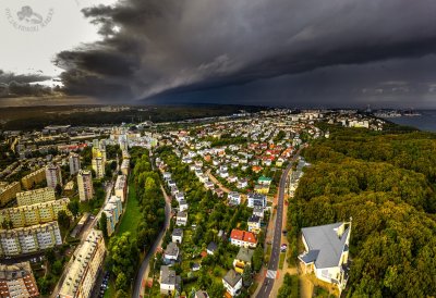 Zdjęcie lotnicze, dzielnica Redłowo, domy jednorodzinne i bloki, ulice, zielony las na Kępie Redłowskiej, fragment zatoki, nabrzeże i plaże