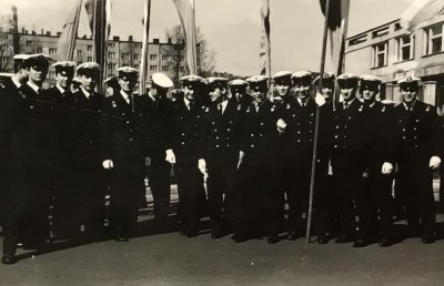 Stara, czarno-biała fotografia z 1965 roku. Grupa studentów w galowych mundurach pozuje do zdjęcia