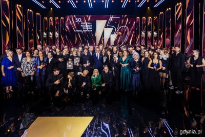 Scena Teatru Muzycznego, dekoracje FPFF, duża grupa ludzi nagrodzonych na gali pozuje do zdjęcia