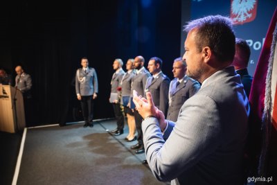 Scena Konsulatu Kultury. W rzędzie stoi kilkoro policjantów w mundurach, na pierwszym planie Marek Łucyk.
