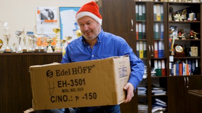 Dyrektor w czapce Mikołaja z pudłem