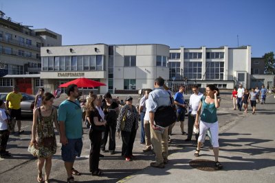 Grupa osób z przewodnikiem stoi na placu w Gdyni