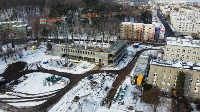 Plac budowy na terenie kampusu Uniwersytetu Morskiego w Gdyni. Widoczne ściany budynku hali sportowej, który powstaje obok budynków uczelni. Obok wykopy, ulica, bloki mieszkalne przy ul. Grabowo.