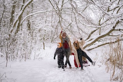 na zdjęciu rodzina bawiąca się w śniegu