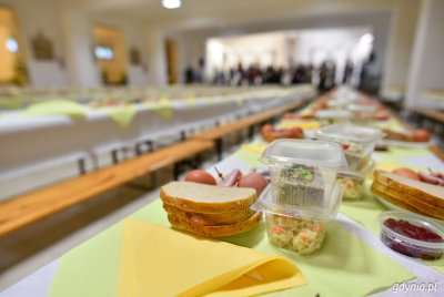 Długi stół z nakryciem, porozstawiane świąteczne potrawy w jednorazowych opakowaniach