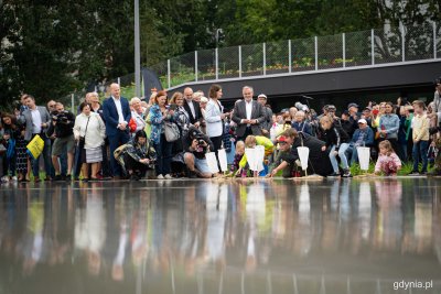 Park Centralny, tłum ludzi, sadzawka z wodą, kilkoro dzieci puszcza na wodę żaglówki, deszczowa pogoda