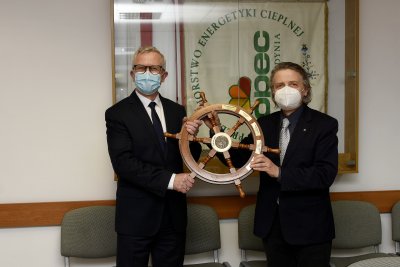 Wojciech Folejewski i Janusz Różalski pozują do zdjęcia w gabinecie. Trzymają drewniany ster z grawerami