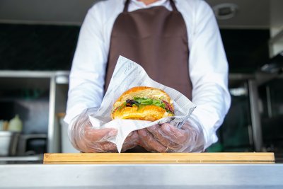 Ręce mężczyzny trzymają burgera w food trucku