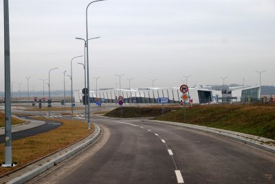 Fragment asfaltowej drogi, na drugim planie budynek terminala Portu Lotniczego Gdynia-Kosakowo.