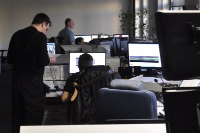 Pomieszczenie w urzędzie miasta, widoczne biurka i monitory, dwie osoby przy biurku