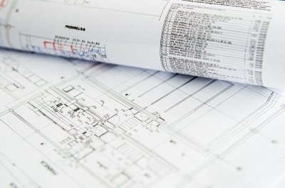 Zdjęcie kartek z projektem architektonicznym, widoczne rysunki i tabele