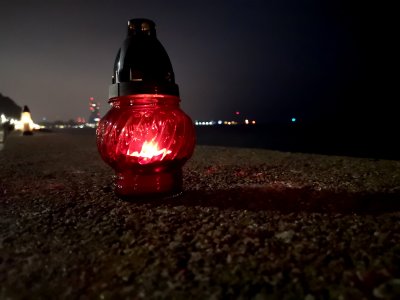 na zdjęciu zapalony znicz na murze bulwaru