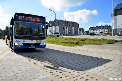 Midibus z nazwą lini 137 stoi na tle bloków mieszkalnych na osiedlu Puszczyka