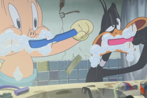 Kadr z filmu „Looney Tunes: Porky i Daffy ratują świat”. Animowane postaci Daffy i Porky myją zęby przeglądając sie w lustrze.