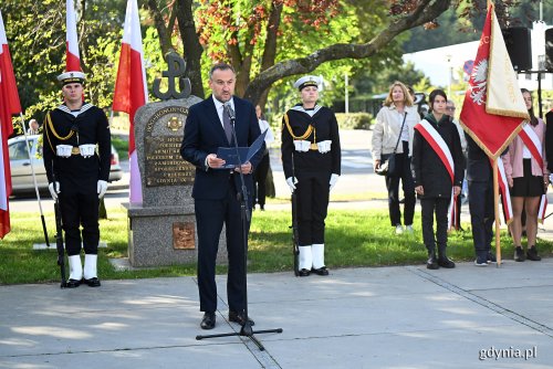Pomnik Armii Krajowej w Gdyni, przy pomniku żołnierze w mundurach, przemawia do mikrofonu Tomasz Augustyniak