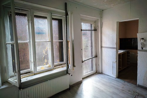 Puste pomieszczenie w mieszkaniu, widoczne okna i drzwi balkonowe, zabezpieczenia antywłamaniowe