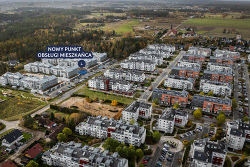 Zdjęcie lotnicze fragmentu Chwarzna-Wiczlina, widoczne osiedla wielorodzinne, ulica Tęczowa, zabudowania, na niebiesko zaznaczony lokal urzędu, napis 