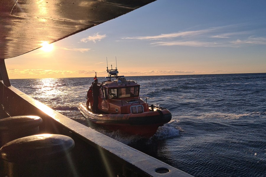 Pomarańczowa łódź ratownicza płynie obok okrętu Marynarki Wojennej podczas ćwiczenia taktycznego na Bałtyku. W tle zachód słońca // fot. archiwum dOW