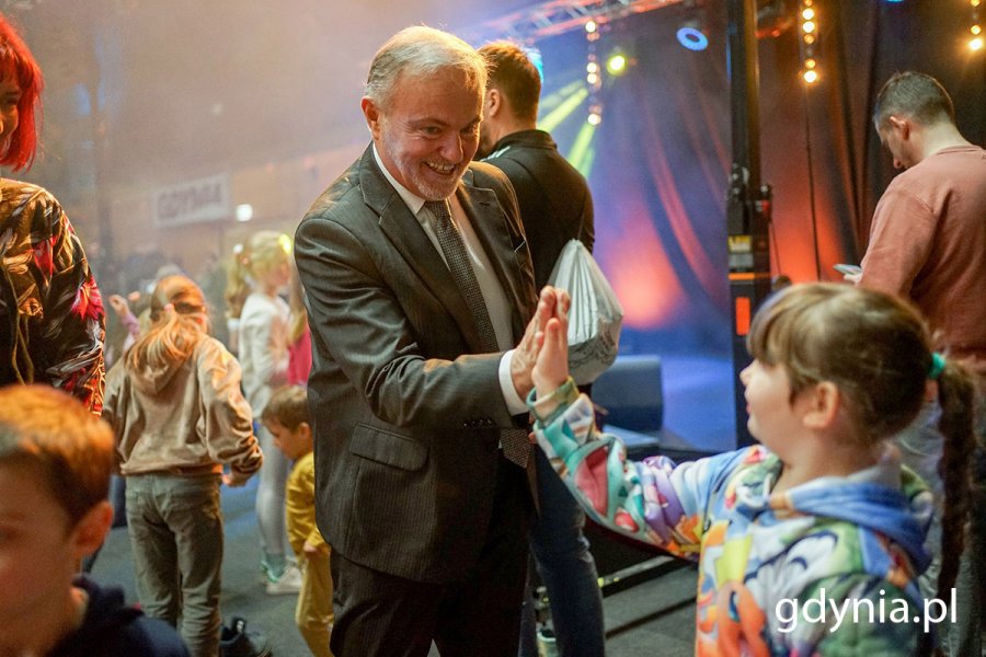 Mężczyzna - prezydent Gdyni przybija piątkę dziecku na balu rodzinnym.