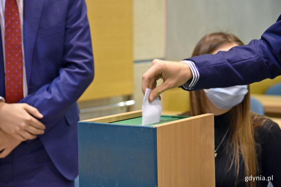 Wybory prezydium. Jeden z radnych wrzuca kartę do głosowania do urny // fot. Magdalena Czernek