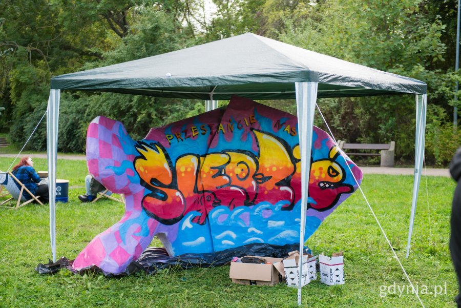 Instalacja w kształcie ryby, na kt&oacute;rej namalowane jest graffiti.