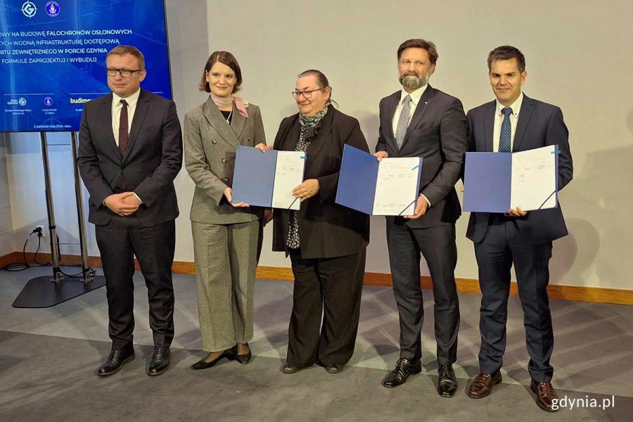 Grupa ludzi pokazująca umowy