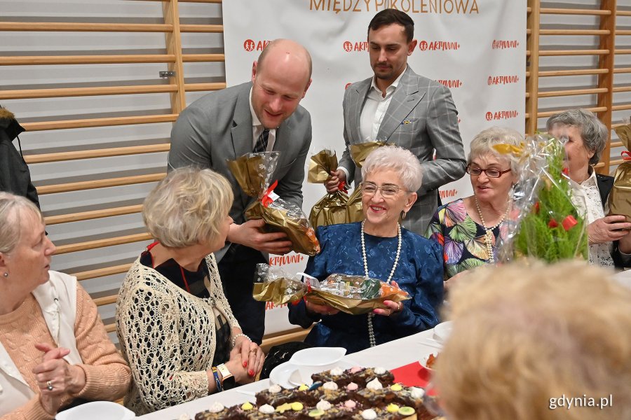 Wigilia dla seniorów w Przystani Chylońska 237, na zdjęciu wiceprezydent Bartoszewicz wręcza seniorom drobne upominki