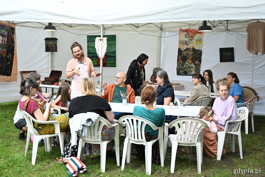 Dorośli siedzący przy stole podczas warsztatów w jednej z festiwalowych stref