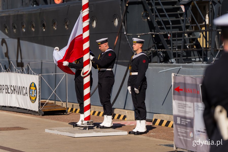 Marynarze wciągają na maszt polską flagę