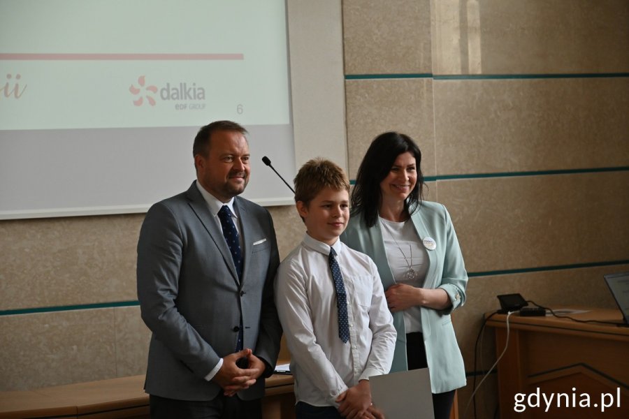 Wiceprezydent Marek Łucyk i Ewa Gałecka z Dalkia Polska pozują do zdjęcia z nagrodzonym uczniem