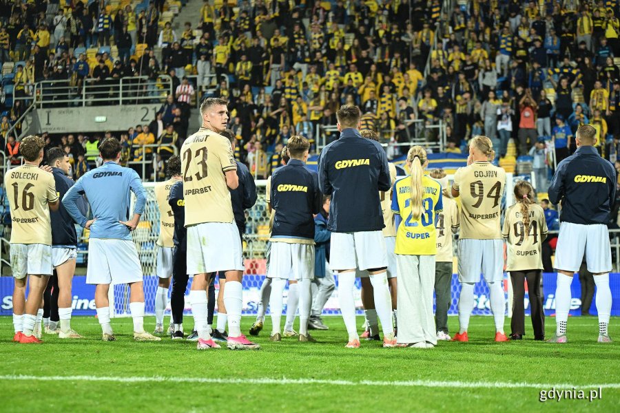 Kibice i piłkarze Arki Gdynia wsp&oacute;lnie cieszący się po meczu