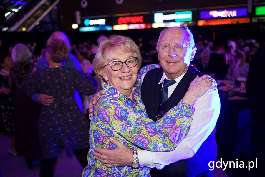 Seniorzy bawią się na balu karnawałowym na lotnisku.