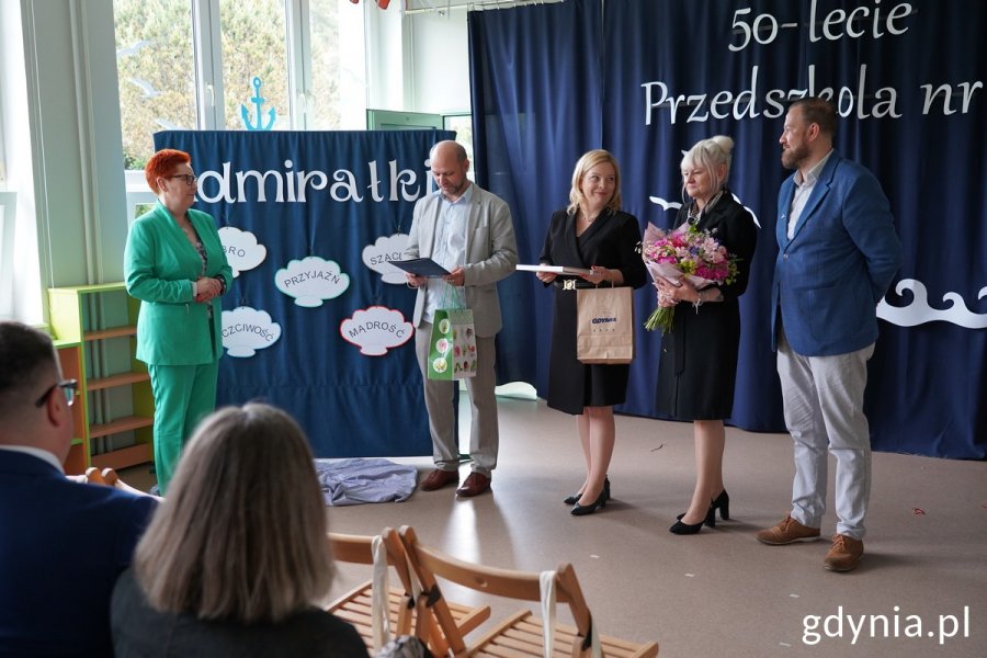 Wiceprezydentka Gdyni Oktawia Gorzeńska, wiceprzewodniczący Rady Miasta Gdyni Ireneusz Trojanowicz, radny Łukasz Strzałkowski i naczelniczka Wydziału Edukacji Iwona Tanewska wręczają dyrektor przedszkola Joannie Długońskiej-Duber kwiaty i drobne upominki