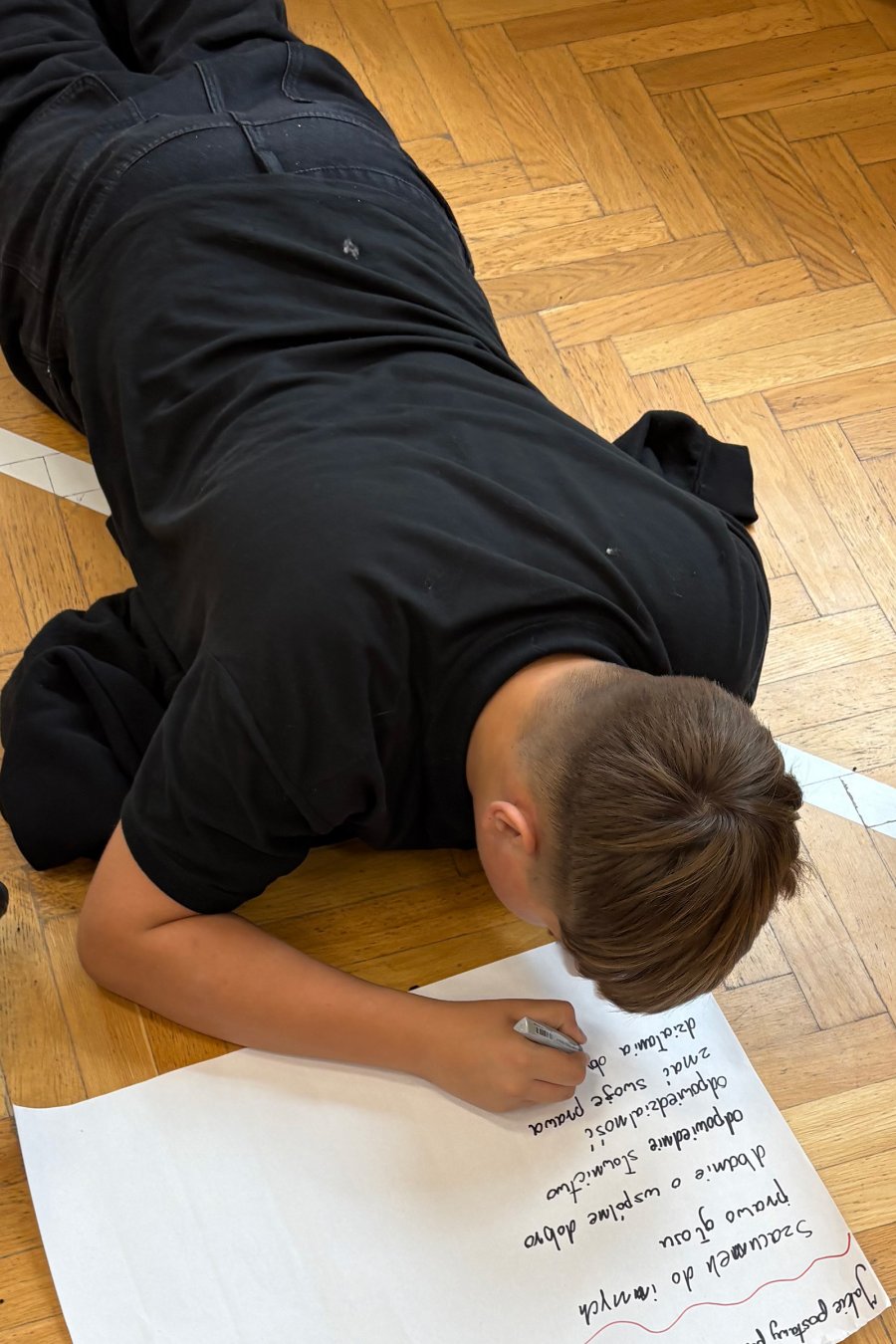 Młodzież leżąca na podłodze w trakcie  debaty poświęconej edukacji obywatelskiej