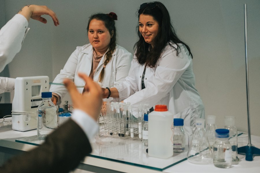 Studenci w białych fartuchach z odczynnikami