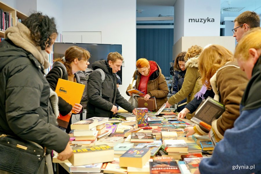 Uczestnicy charytatywnego kiermaszu w Bibliotece Śr&oacute;dmieście podczas przeglądania książek 