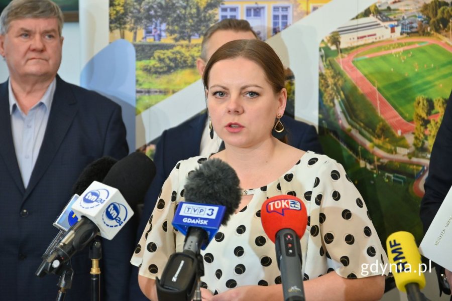 Aleksandra Kosiorek, prezydent Gdyni, stojąca przed mikrofonami