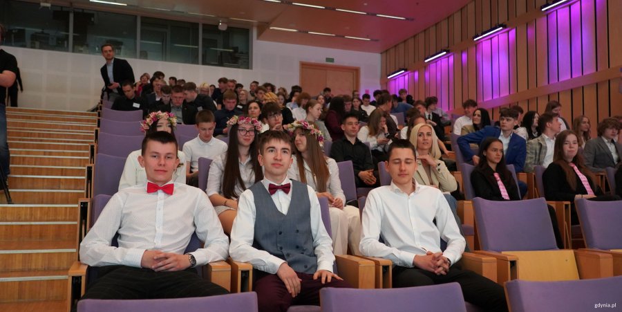 Młodzi chłopcy w białych koszulach i czerwonych muchach na widowni