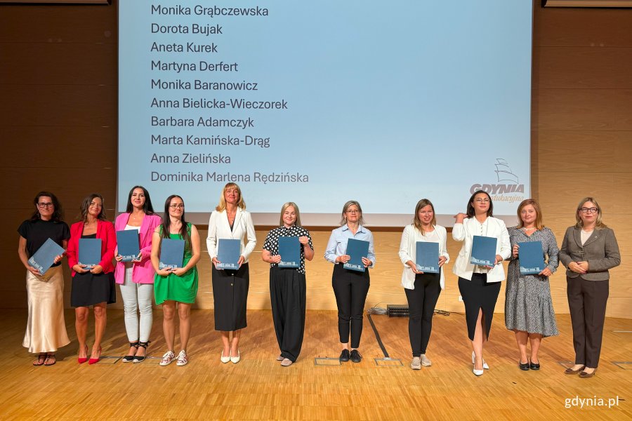 Osoby na scenie pozujace po wręczeniu nominacji