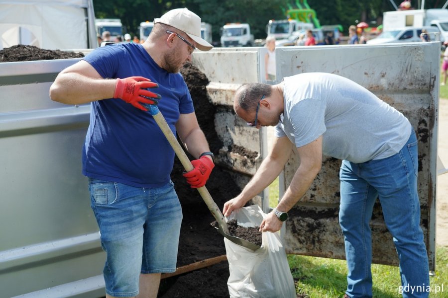 Dwóch mężczyzn nakłada do worka kompost wytworzony przez Eko Dolinę z bioodpadów zebranych w naszych mieście