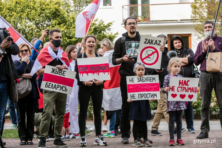 Uczestnicy akcji "Stop przemocy przeciwko narodowi Białorusi" z flagami i protestacyjnymi tabliczkami w rękach // fot. Karol Stańczak