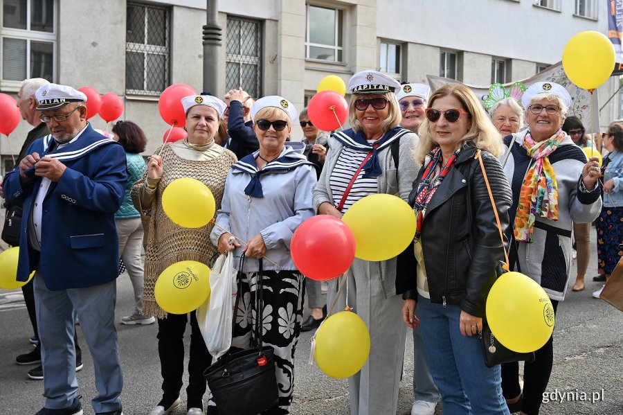 Uczestnicy przemarszu w ramach V Pomorskiego Dnia Seniora. W rękach trzymają kolorowe balony