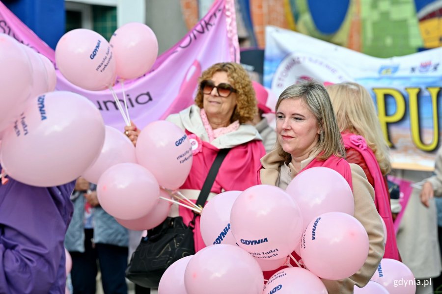 Uczestniczki Marszu R&oacute;żowej Wstążki z balonami w rękach przed Teatrem Miejskim w Gdyni 