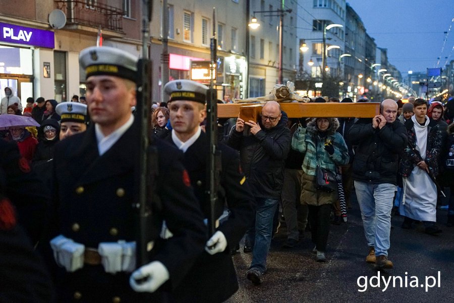 Ludzie idą ulicami miasta w czasie drogi krzyżowej.