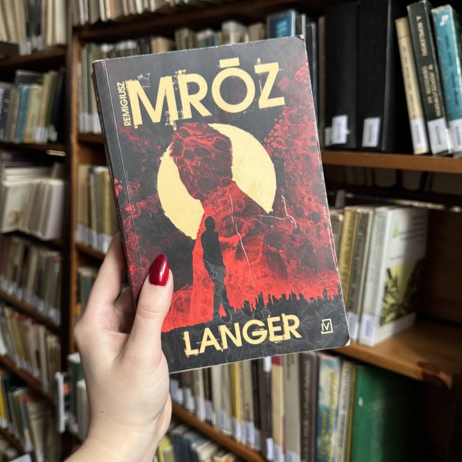 Kobieca dłoń trzymająca książkę „Langer”